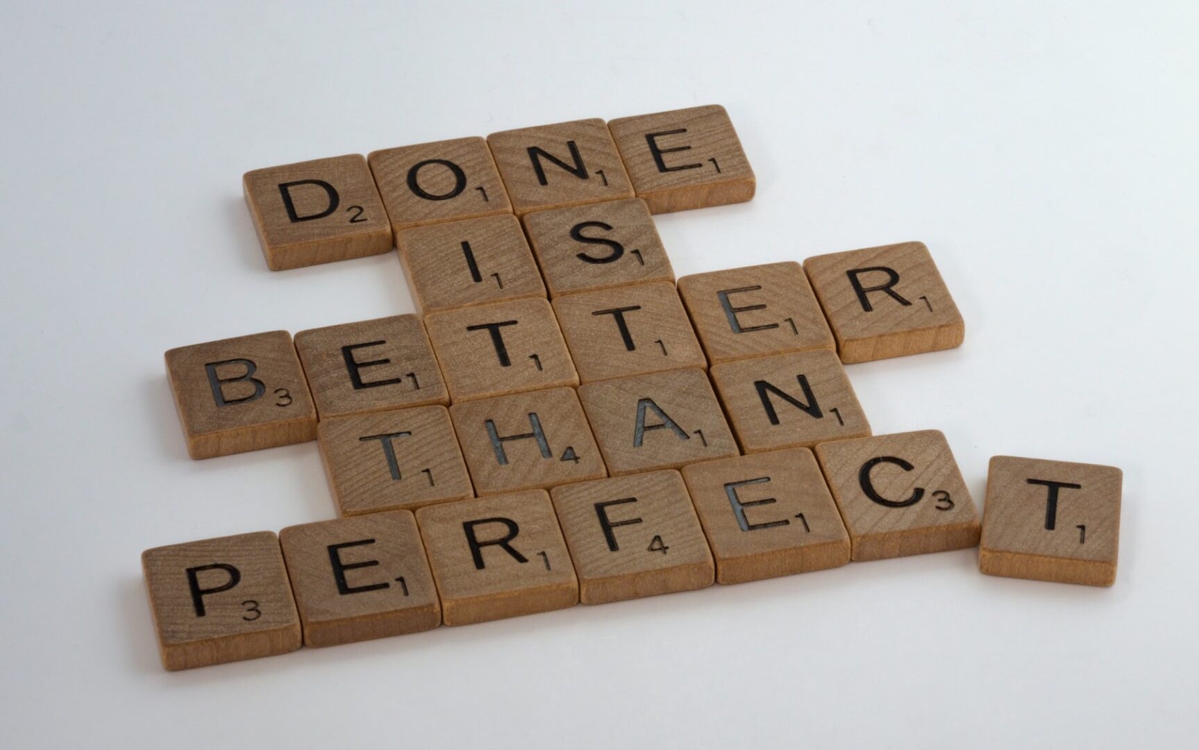 A word game with scrabble tiles that say " done is better than perfect ".